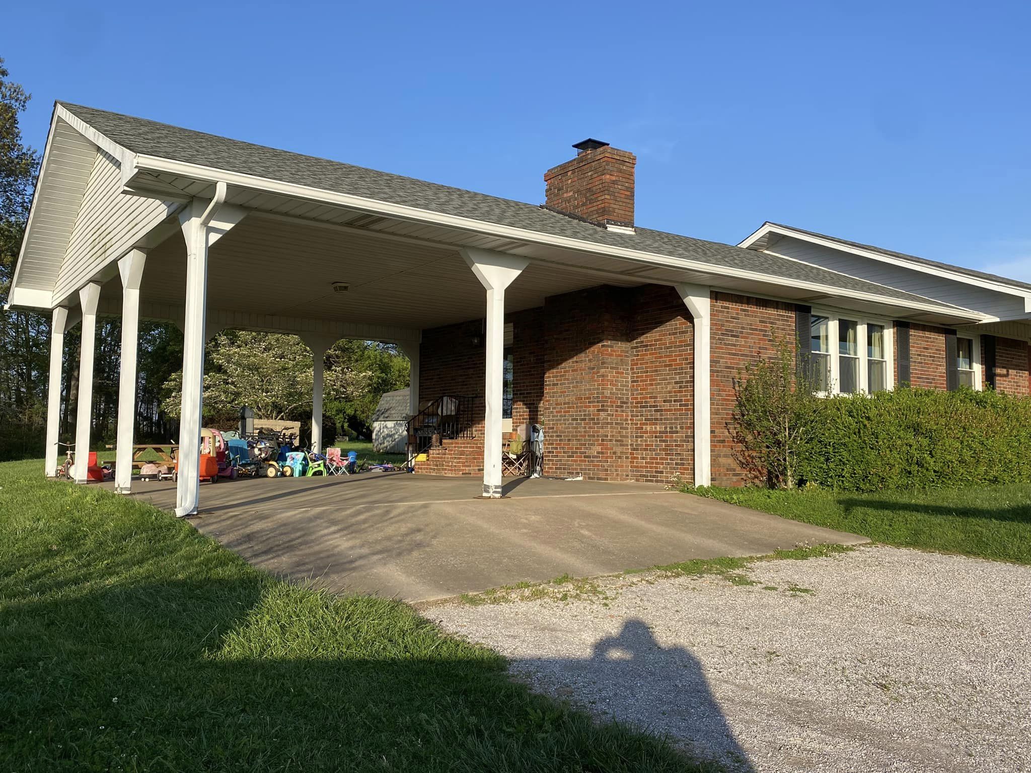 A house with a covered patio and a car parked in front of it