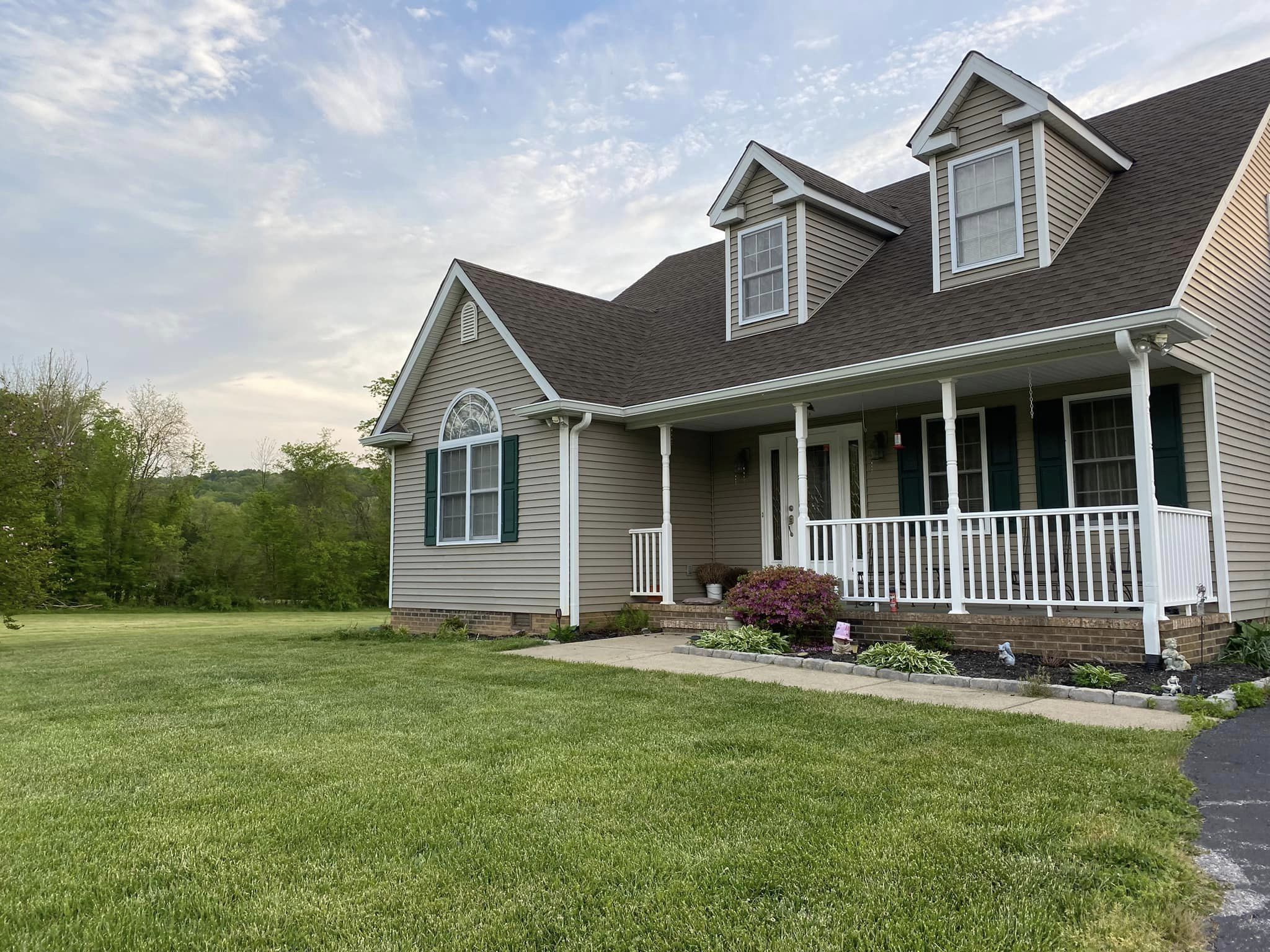 A house with a large front yard and a covered porch