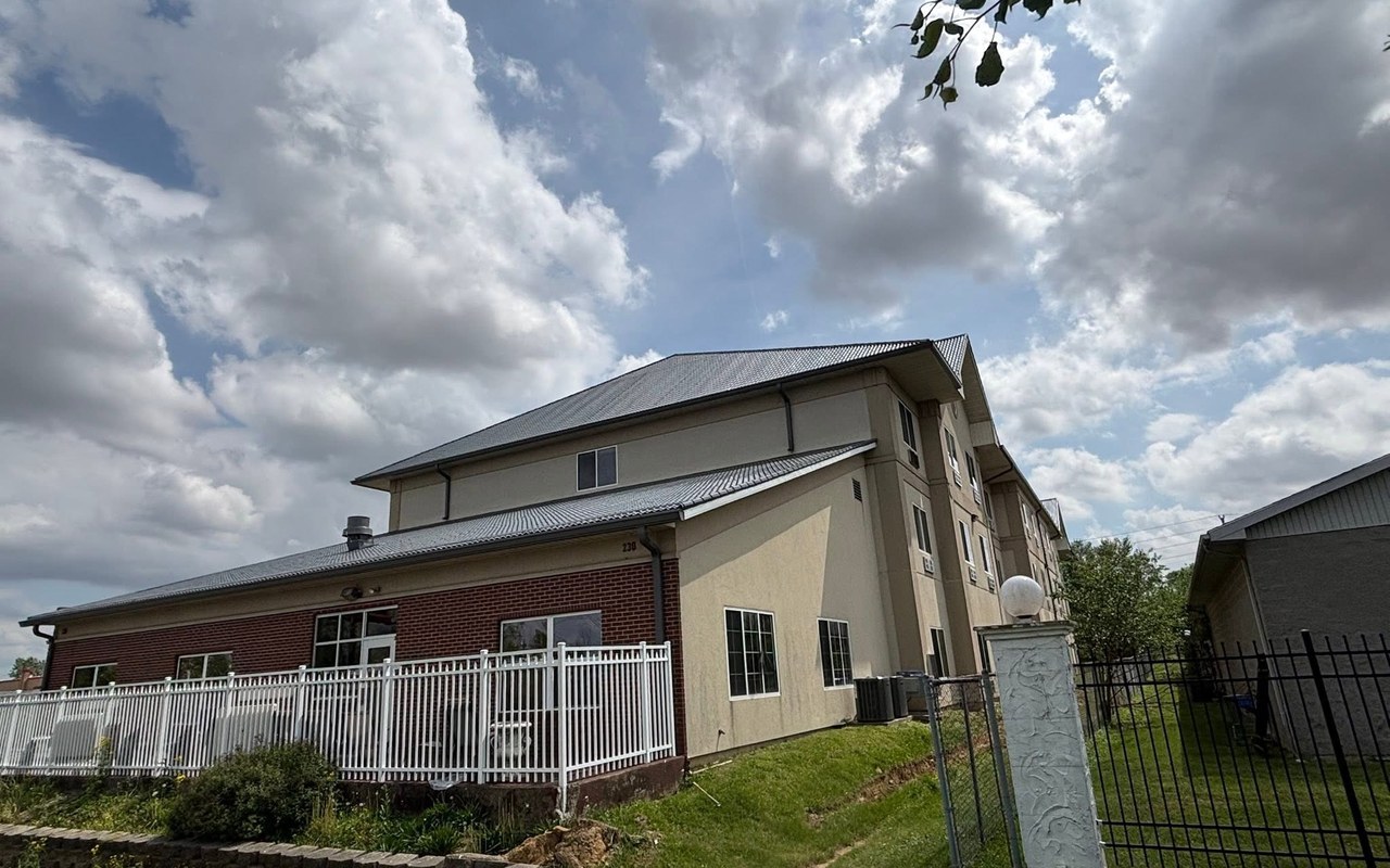 Long commercial roofline fitted with seamless gutters on a Kentucky property